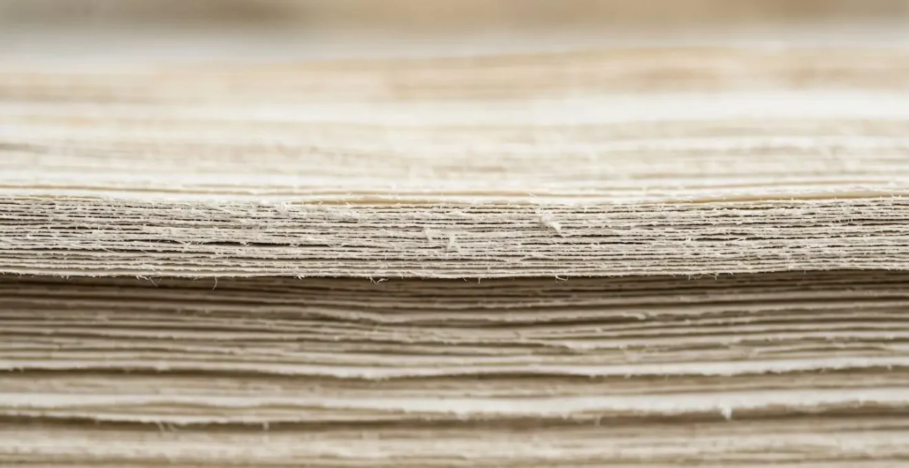 Extreme close-up of layered paper documents with subtle textures, symbolizing the hidden layers and complexity of unbundled medical billing services.