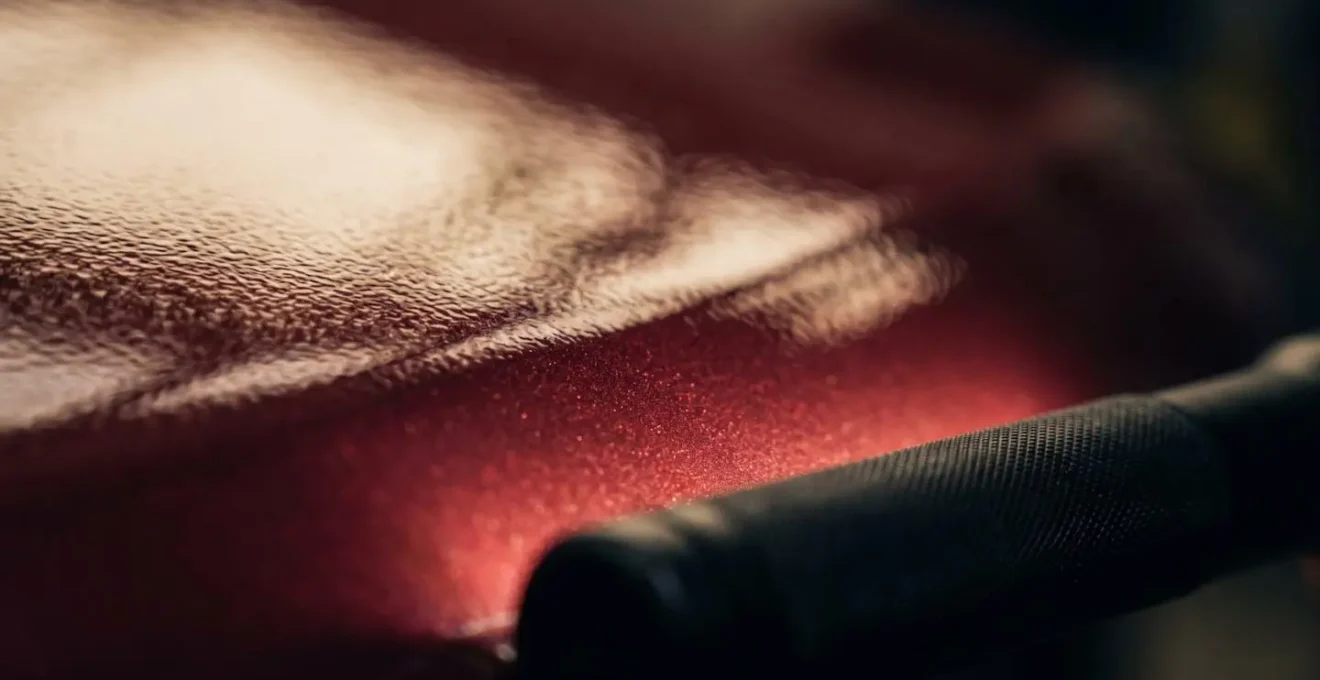 Close-up detail of automotive paint surface inspection showing professional quality control techniques