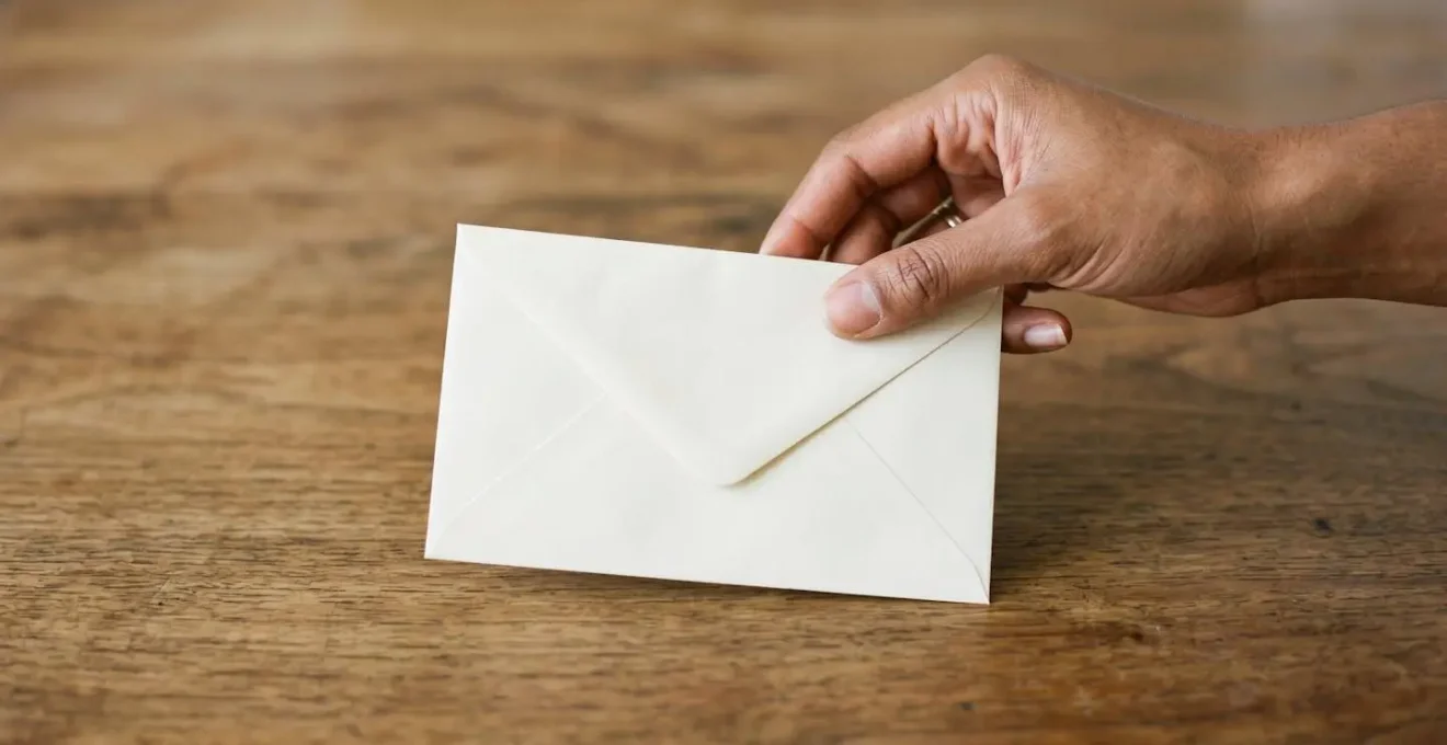 A hand placing an official document on a clean surface symbolizing civic registration
